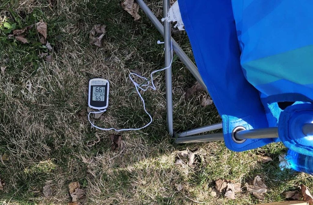 Photo of a cheap digital thermometer in the shade with its sensor located about 4" above the grass surface.